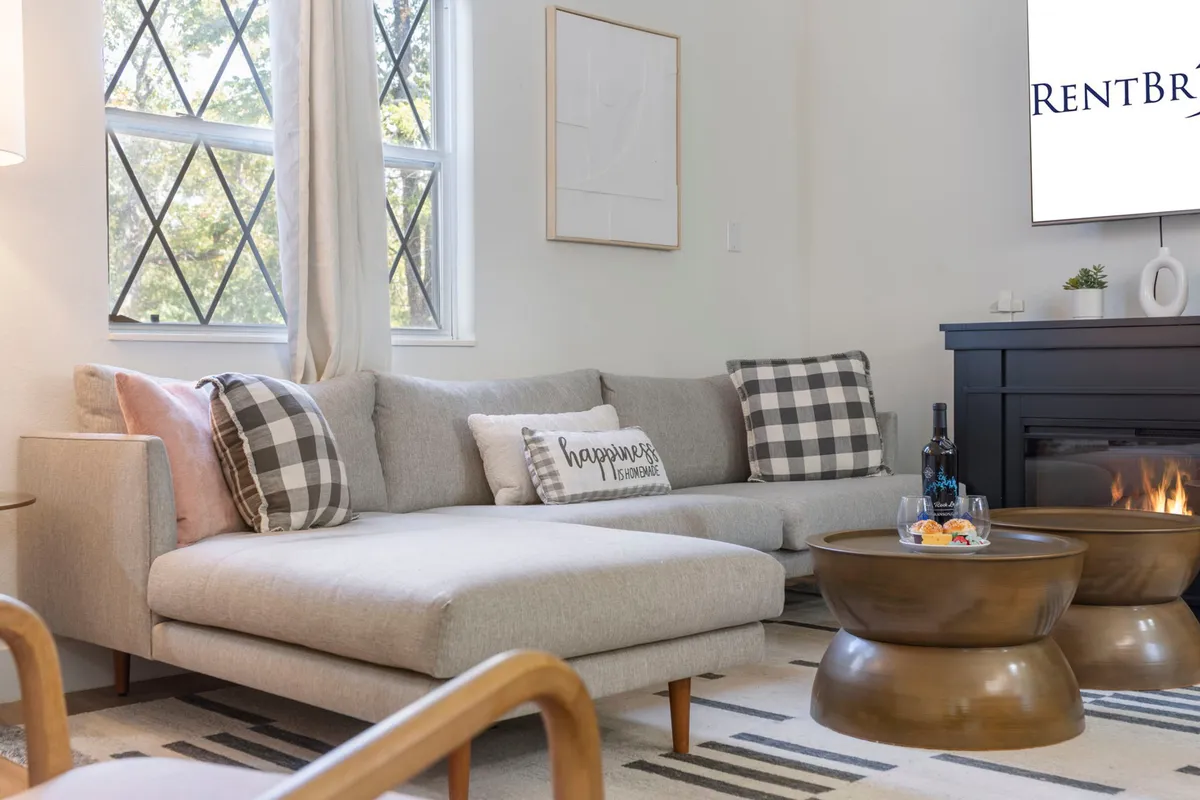 A cozy common area with a sofa, coffee table, television, and decorative pillows, creating a comfortable atmosphere ideal for relaxing, entertaining, or enjoying streaming TV.