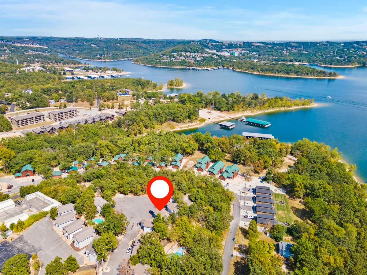 This scenic exterior showcases the tranquil lake, lush greenery, and several cabins near boating docks. People are seen partaking in boating, hiking, and picnicking, offering a sense of adventure and relaxation in the natural environment. The image conveys accessibility to water activities and the outdoors for all ages.