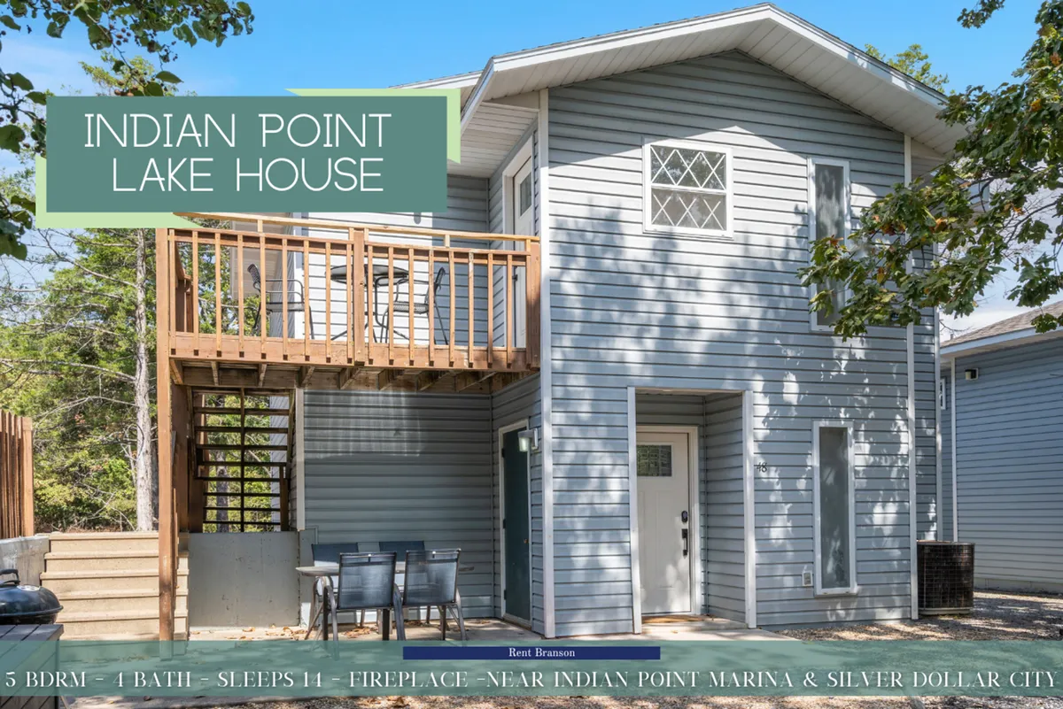 The exterior shot captures the welcoming front entrance, balcony, and expansive deck area of the Indian Point Lake House. Family members are seen gathering outdoors, enjoying meals, and relaxing with the scenic lake visible in the background. The vibe is open and inviting, emphasizing opportunities for socializing and embracing the nearby nature.